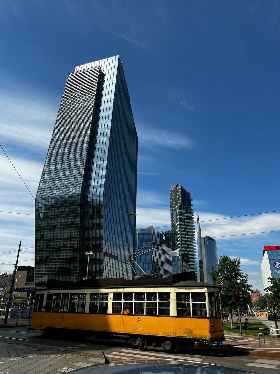 An antique trolley rumbles past modern skyscrapers- symbolic of Milan, old and new Milan02Milan Karl Smith